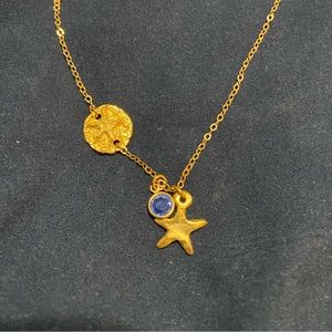 Gold necklace with sand dollar and blue charm. Never worn